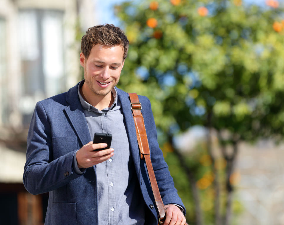 Image of a man typing on a mobile phone